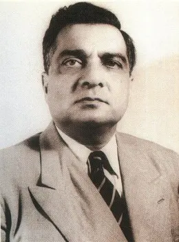স্যুট ও ডোরাকাটা টাই পরা মধ্যবয়সী ইস্কান্দার মির্জার সাদাকালো প্রতিকৃতি