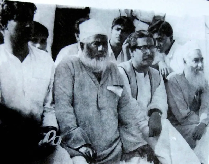 সাদাকালো ছবি: পাশাপাশি বসা সাদা দাড়ি ও টুপি-পরা মওলানা ভাসানী, চশমা-পরা শেখ মুজিব ও আরেক প্রবীণ নেতা, পেছনে তরুণেরা